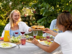 Finom ételekkel kínálják egymást a kerti parti vendégei.